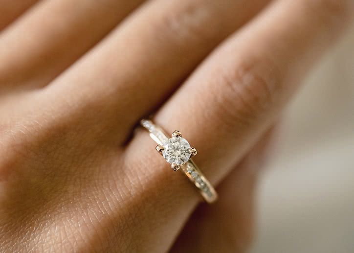 Side stone ring in 18K gold with a 0.5-carat center diamond from VANBRUUN